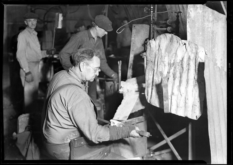 Millville, New Jersey - Glass bottles. T. C. Wheaton gaffer finishing necks of wide mouthed jars. He rotates the... - NARA - 518639