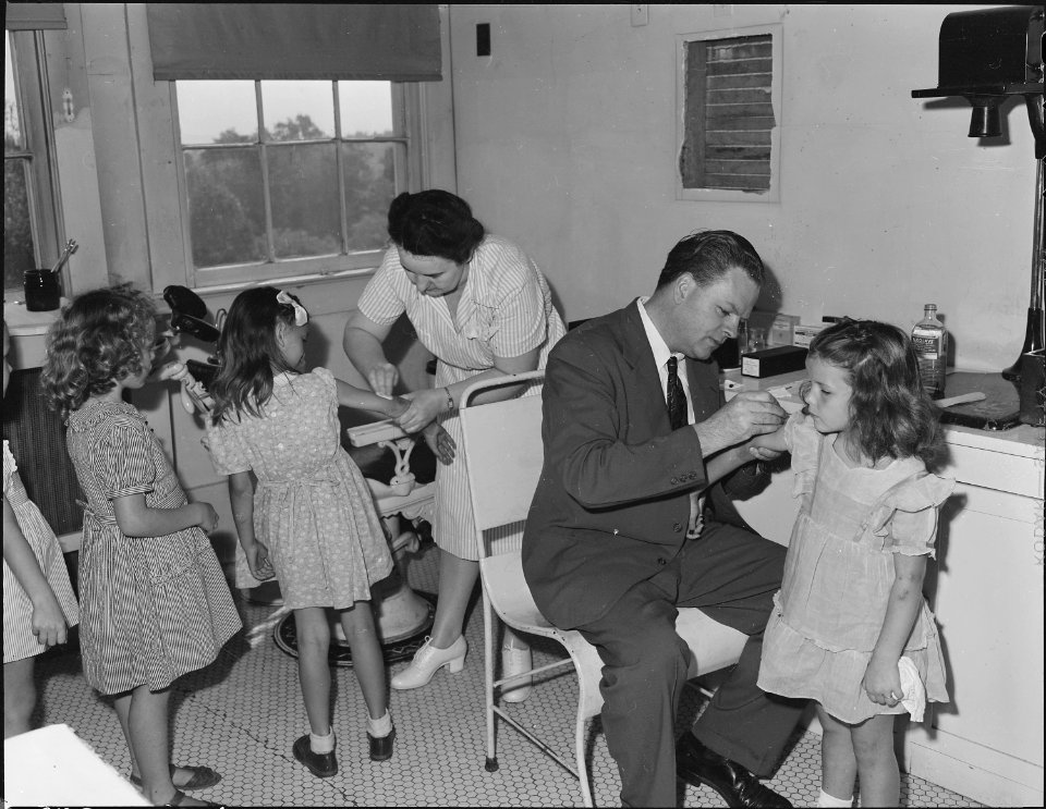 Miner's children being given pre-school examination and being vaccinated for smallpox by Dr. Tiernan, company doctor.... - NARA - 540703