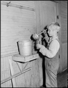 Miner's son getting drinking water from the open bucket at school. Kentucky Straight Creek Coal Company, Belva Mine.... - NARA - 541227