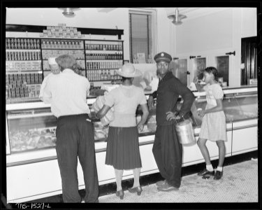 Miners and families at the meat counter in subsidiary company store. Store has ample, clean refrigerated space. The... - NARA - 540840