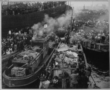 North Korean refugees use anything that will float to evacuate Hungnam. Here they jam the decks of a South Korean... - NARA - 520782