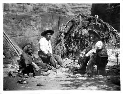 Old Havasupai Indian man telling stories to two other men sitting around a campfire, ca.1899 (CHS-3790)