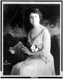 Olga Samaroff Stokowski, three-quarter length portrait, seated, facing slightly left, holding book LCCN94515632