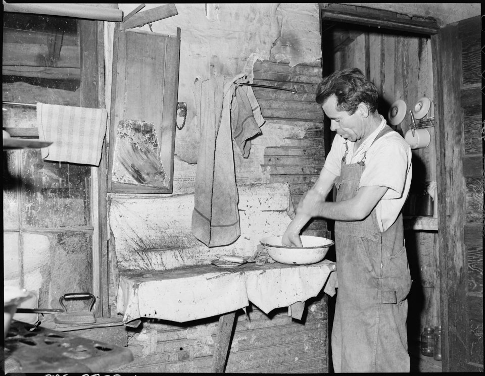 Oliver Hinkle, disabled miner, washing his hands in the kitchen. Kentucky Straight Creek Coal Company, Belva Mine.... - NARA - 541230