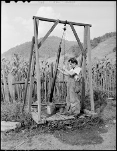 Oliver Hinkle getting water from well which is used by about seven families. Kentucky Straight Creek Coal Company... - NARA - 541213 photo