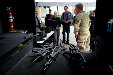 Onlooking law enforcement explorers examine weapons photo
