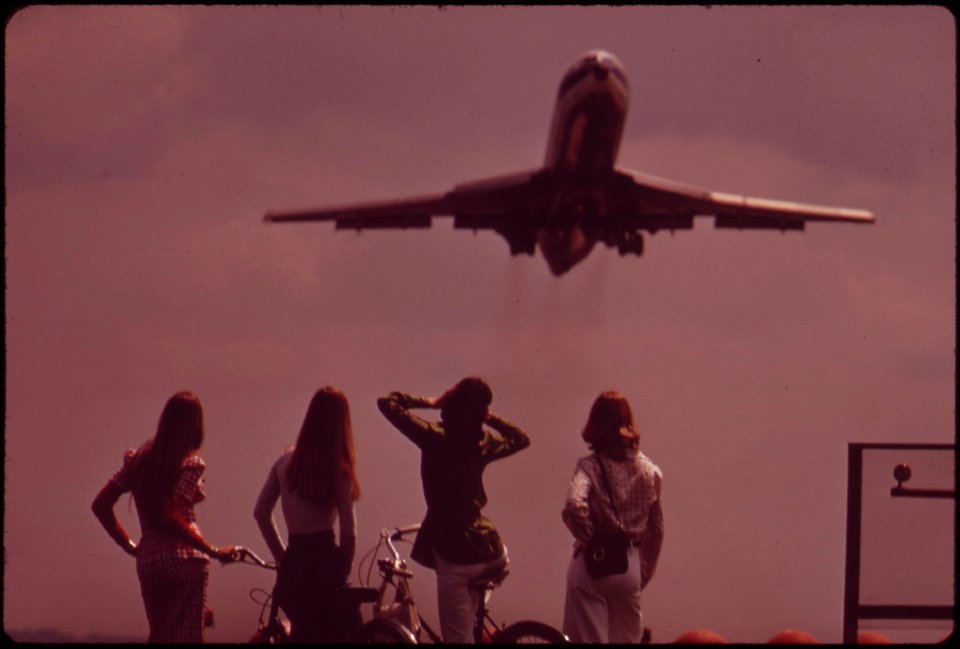 One-of-the-bicyclists-holds-her-ears-against-the-roar-of-the-jet-taking-off-from-national-airport-may-1973 7461373190 o