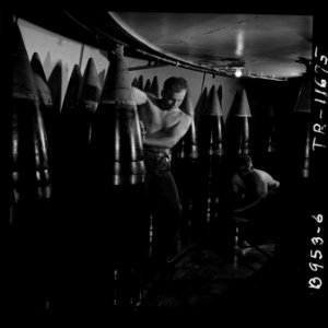 Ordnancemen moving 16 shell from its storage stall to ammunition hoist on board the USS New Jersey (BB-62). - NARA - 520878