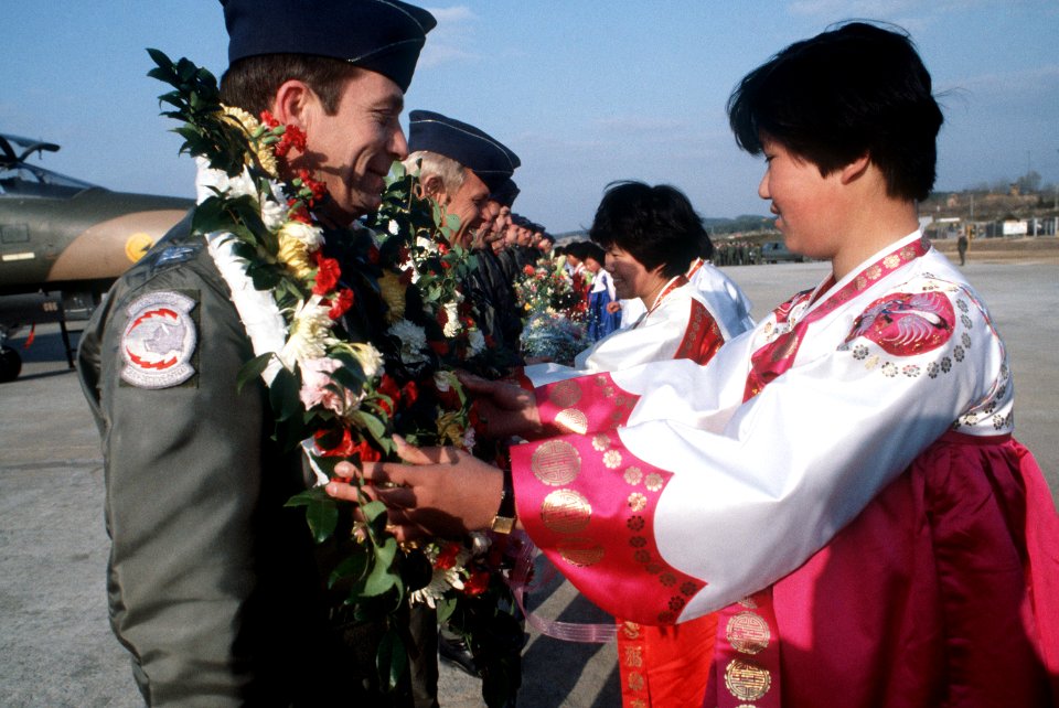 Orean women welcome the flight crews of a US Air Force F-111 squadron upon their arrival for Exercise DF-ST-87-13247