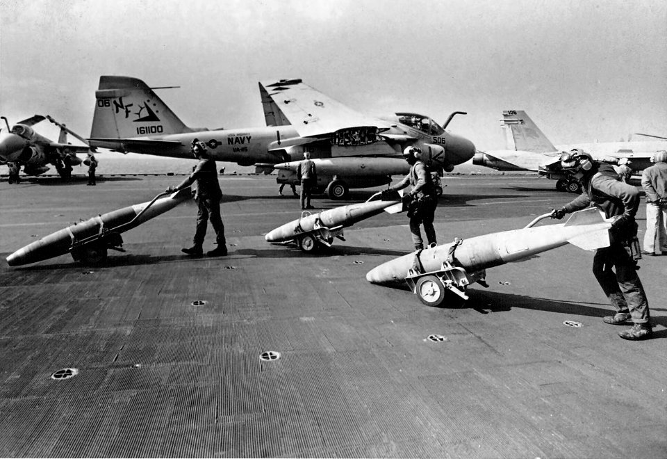 Ordnancemen push bombs on flight deck of USS Midway (CV-41) in 1991