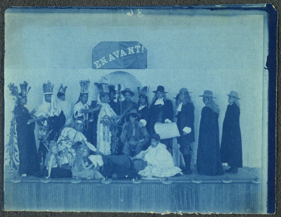 Pageant participants costumed as Pilgrims and Natives, posed beneath a banner En Avant! LCCN2001697165