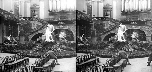 Orgue , estàtues , cadires i un home a l'interior del Palau de Belles Arts de l'Exposició Universal de Barcelona