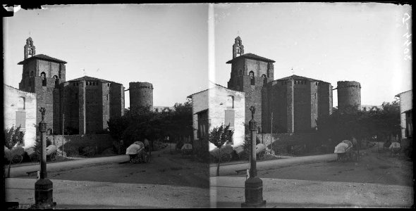 Part posterior de la col·legiata de Tremp i en primer terme una plaça amb una creu i un carro