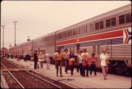 Passengers-of-the-southwest-limited-strolling-beside-the-amtrak-train-at-albuquerque-new-mexico-as-it-halts-for-refueling-enroute-to-chicago-from-los-angeles-california-june-1974 7158183264 o photo