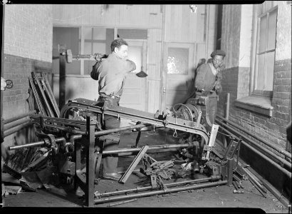 Paterson, New Jersey - Textiles. Junkies breaking up old looms, to be sold for scrap-iron and said to be sent to... - NARA - 518540