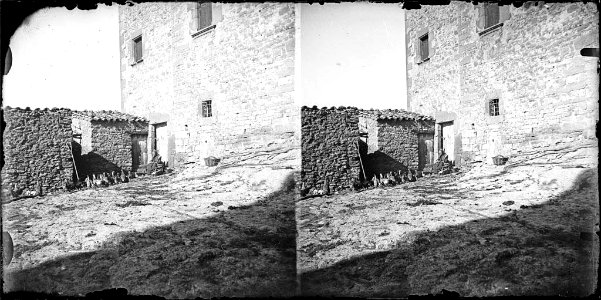 Pati d'una casa amb una dona i gallines