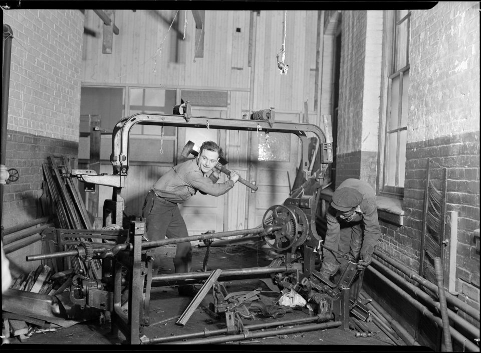Paterson, New Jersey - Textiles. Junkies breaking up old looms, to be sold for scrap-iron and said to be sent to... - NARA - 518539