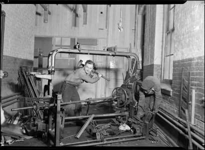 Paterson, New Jersey - Textiles. Junkies breaking up old looms, to be sold for scrap-iron and said to be sent to... - NARA - 518539