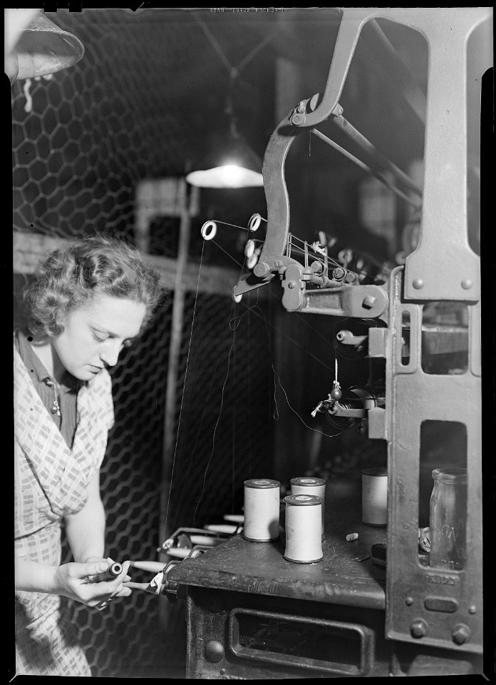 Paterson, New Jersey - Textiles. Quiller removing full quill from spindle and inserting empty quill. Note full... - NARA - 518574