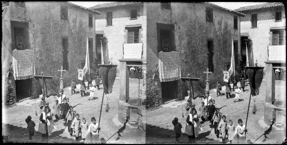 Pas d'una processó per la plaça amb escolanets portant estendards