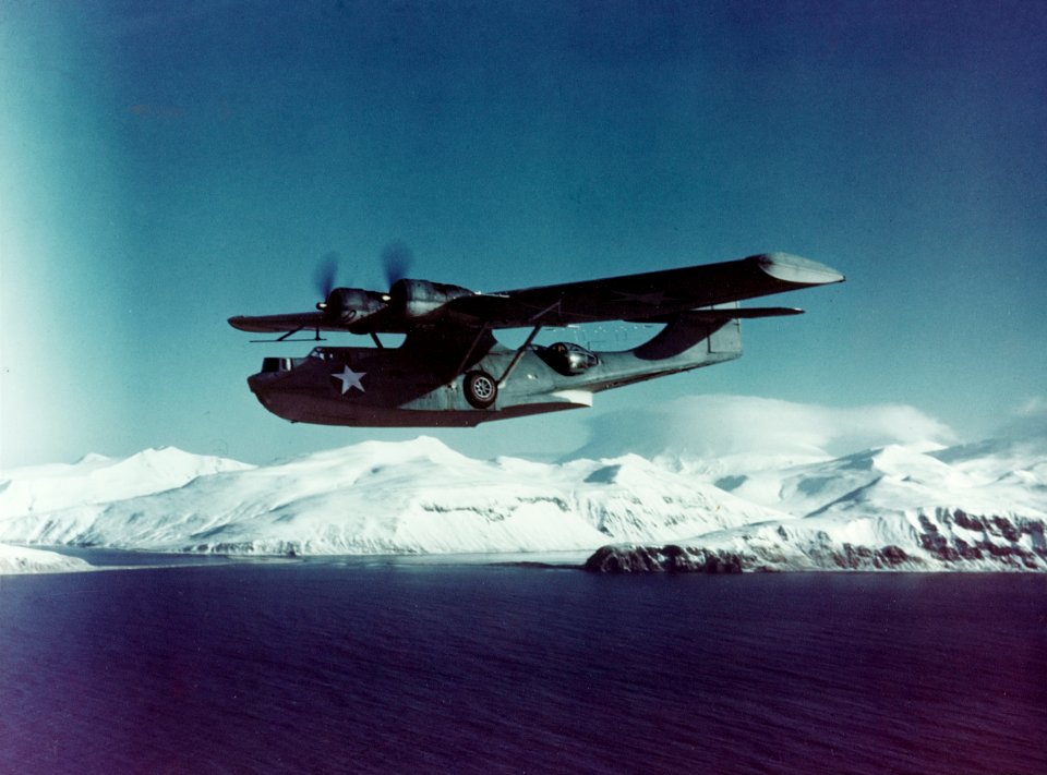 PBY-5A Catalina flies on patrol near a snowy Aleutian Island c1943