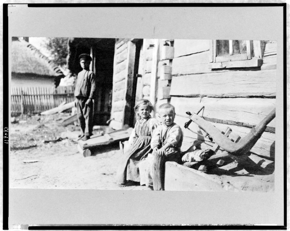 Peasant boy, girl, and man outside of log house, Russia LCCN97517363
