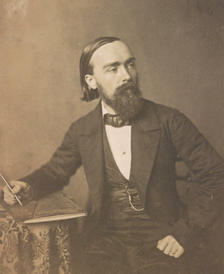 Paul Weber, artist, three-quarter length studio portrait, seated, holding pencil in right hand on sheaf of paper on a table, facing right LCCN2015651551 (cropped)