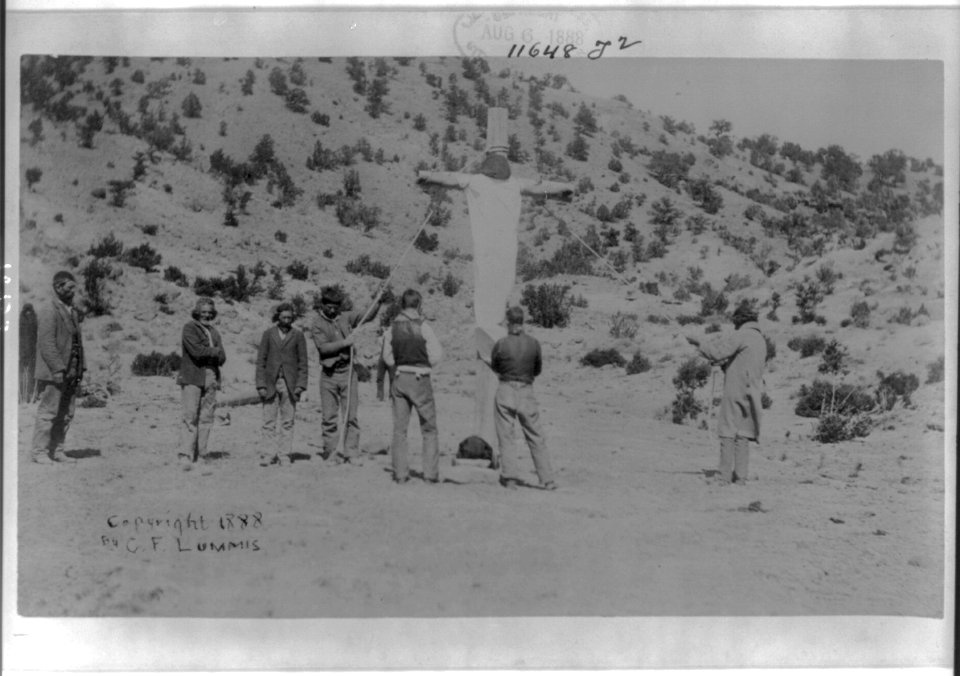 Penitents crucifying one of their own- person on huge wooden cross, which is held up by ropes; men watching LCCN2006684444