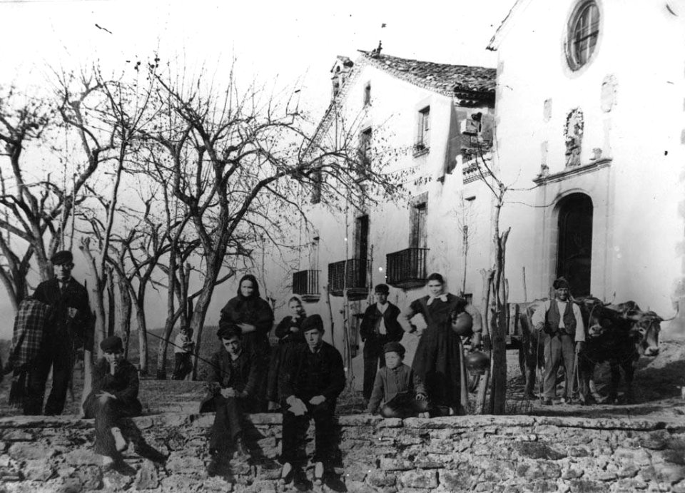 Persones i un carro tirat per bous davant al Santuari de Puiglagulla