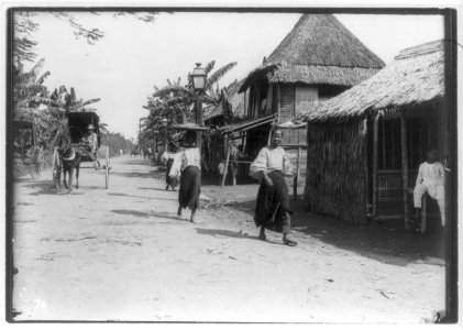 Philippines, Manila, 1899- street scene in suburb, pedestrians and carts; thatched straw houses LCCN2005691617