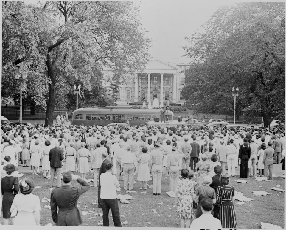 Photograph of a crowd of spectators in Lafayette Park north of the White House (those in uniform saluting) on the... - NARA - 199177