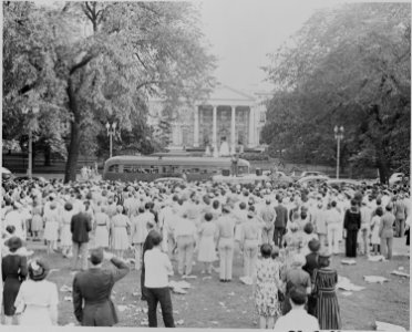 Photograph of a crowd of spectators in Lafayette Park north of the White House (those in uniform saluting) on the... - NARA - 199177