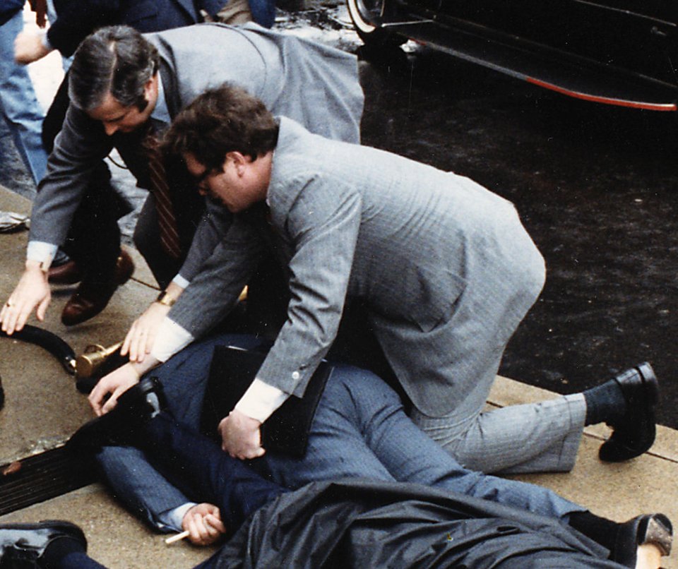Photograph of chaos outside the Washington Hilton Hotel after the assassination attempt on President Reagan (James Brady on the ground) (cropped)