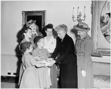Photograph of First Lady Bess Truman at the White House with a delegation of Girl Scouts, who are presenting her with... - NARA - 200404