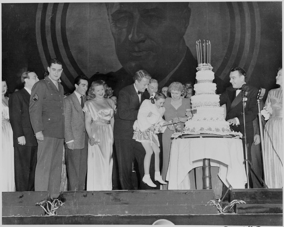 Photograph of First Lady Bess Truman giving a piece of birthday cake to actress Margaret O'Brien during a Roosevelt... - NARA - 199340