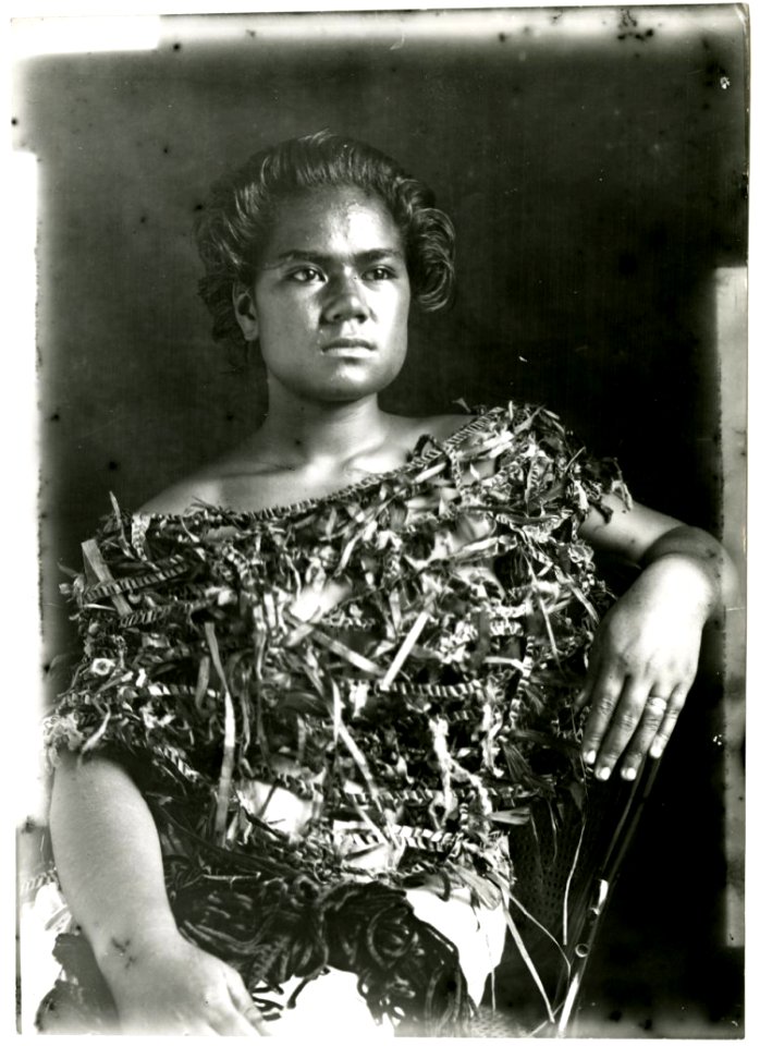 Photograph (black and white); portrait of woman sitting on a western-style chair, wearing a plant fibre top; Oceania. Gelatin silver print. Oc,B130.62, British Museum