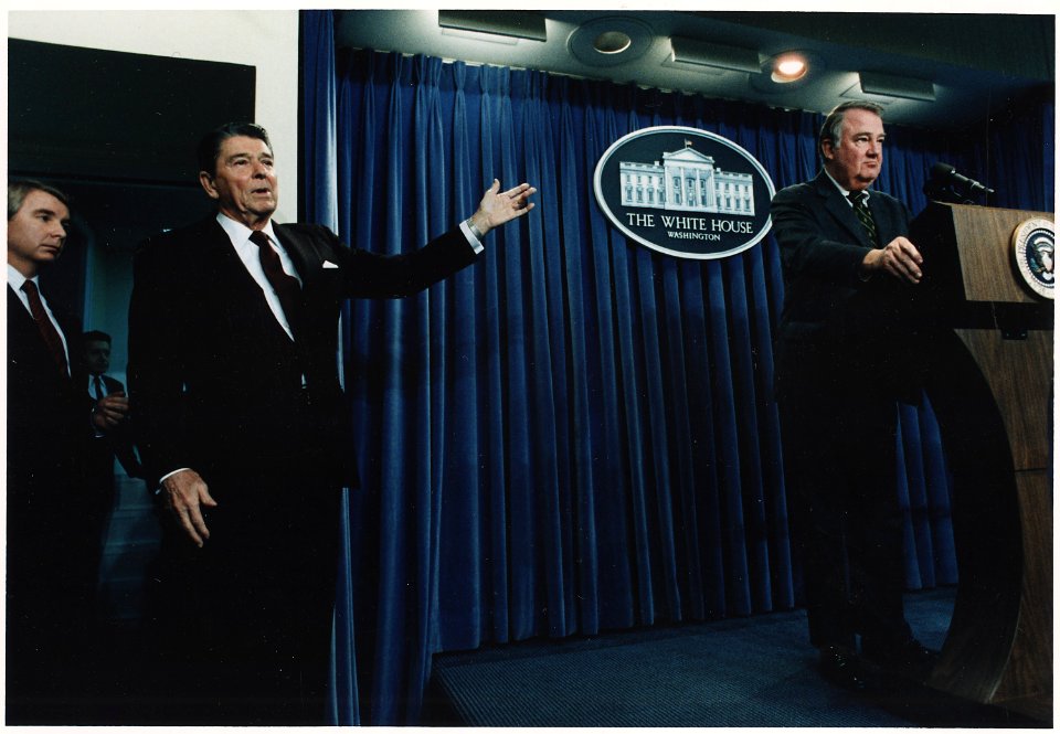 Photograph of President Reagan motioning to Ed Meese during a White House Press Briefing on Iran-Contra - NARA - 198579