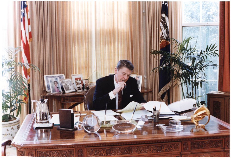 Photograph of President Reagan working at his Oval Office desk - NARA - 198526