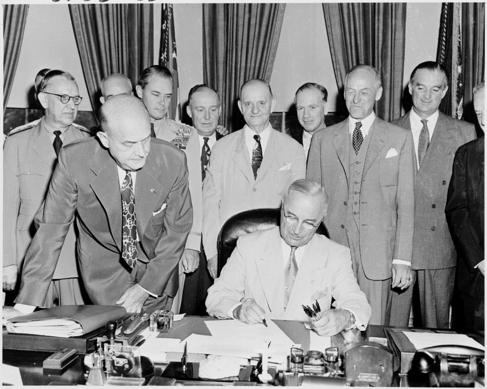 Photograph of President Truman at his desk in the Oval Office, signing the National Security Act Amendments of 1949... - NARA - 200168