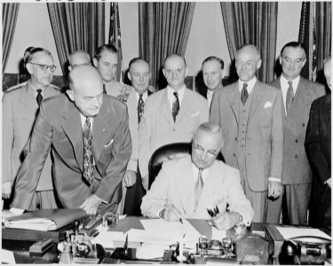 Photograph of President Truman at his desk in the Oval Office, signing the National Security Act Amendments of 1949... - NARA - 200168 photo