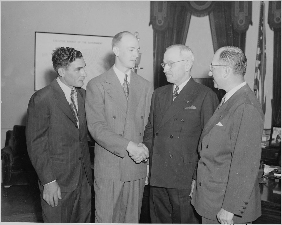 Photograph of President Truman greeting crew members from an around-the-world flight in the Oval Office. - NARA - 199589