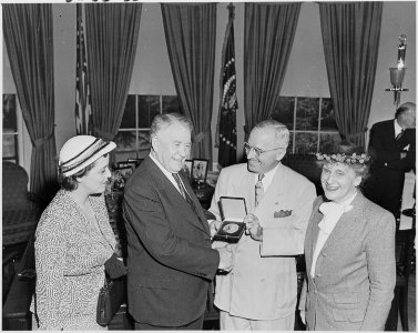 Photograph of President Truman in the Oval Office, shaking hands with Vice President Alben Barkley as he presents him... - NARA - 200220
