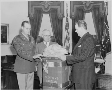 Photograph of President Truman receiving a turkey from Sen. Olin Johnston of South Carolina in the Oval Office, as... - NARA - 199535