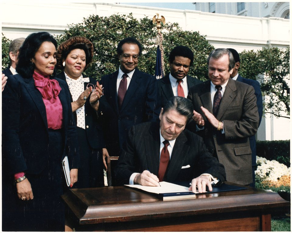 Photograph of President Reagan and the Signing Ceremony for Martin Luther King Holiday Legislation - NARA - 198542