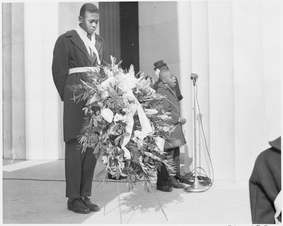 Photograph of an unidentified African-American youth with a wreath at the entrance to the Lincoln Memorial, during... - NARA - 199492