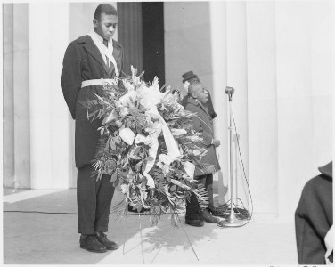 Photograph of an unidentified African-American youth with a wreath at the entrance to the Lincoln Memorial, during... - NARA - 199492 photo