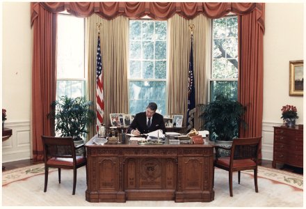 Photograph of President Reagan working at his desk in the Oval Office - NARA - 198593