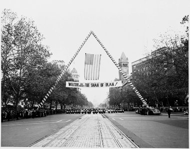 Photograph of a banner welcoming the Shah of Iran to Washington, during a parade in the Shah's honor, with a view of... - NARA - 200146