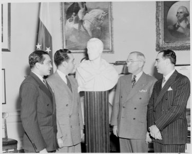 Photograph of President Truman receiving a bust of Simon Bolivar from a Venezuelan delegation in the Oval Office. - NARA - 199534