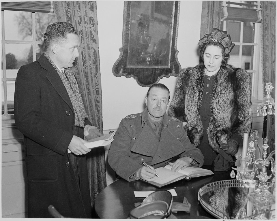 Photograph of Field Marshal Harold Alexander signing a guest book, probably at Mount Vernon, as Mrs. Alexander and an... - NARA - 199509